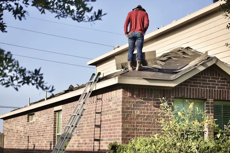 Professional roofer working on a residential roof in Art Village